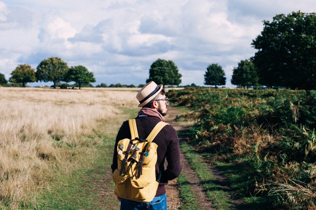 Muž s ruksakom na prechádzke v prírode.jpg